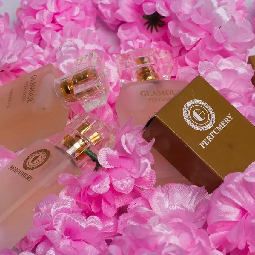 Glamour Perfumery bottles and gift box among pink flowers